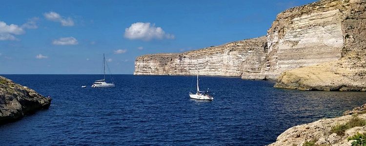 Yacht mooring at buoys in Xlendi Bay